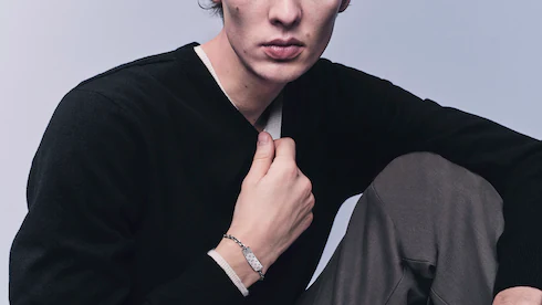 Gros plan sur un mannequin portant un haut noir et un bracelet, style minimaliste.